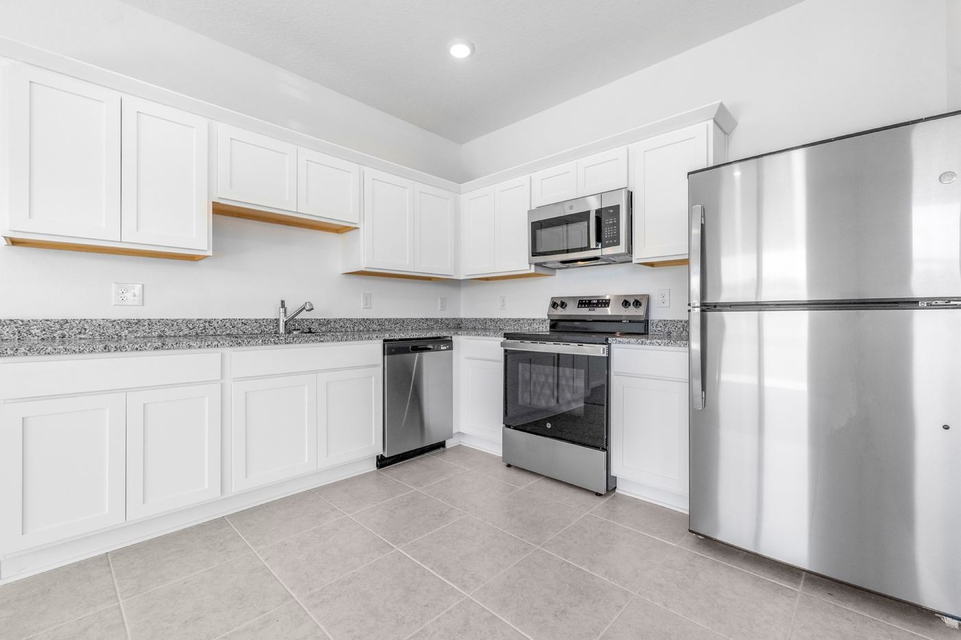 White shaker kitchen with granite counters and stainless appliances